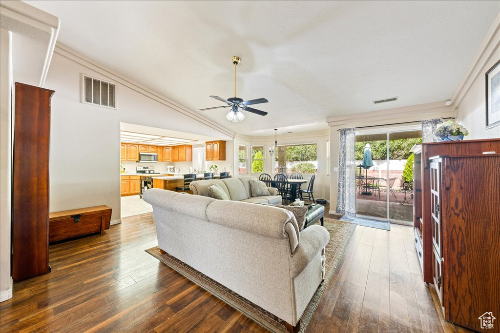 Living area with dark wood finished floors, a ceiling fan, and visible vents
