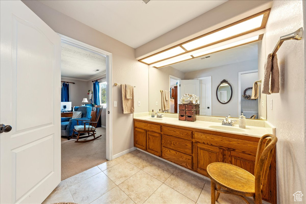 Full bathroom featuring a sink, tile patterned floors, double vanity, and baseboards