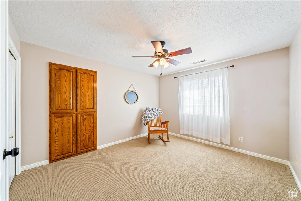 Sitting room featuring light carpet, ceiling fan, and visible vents