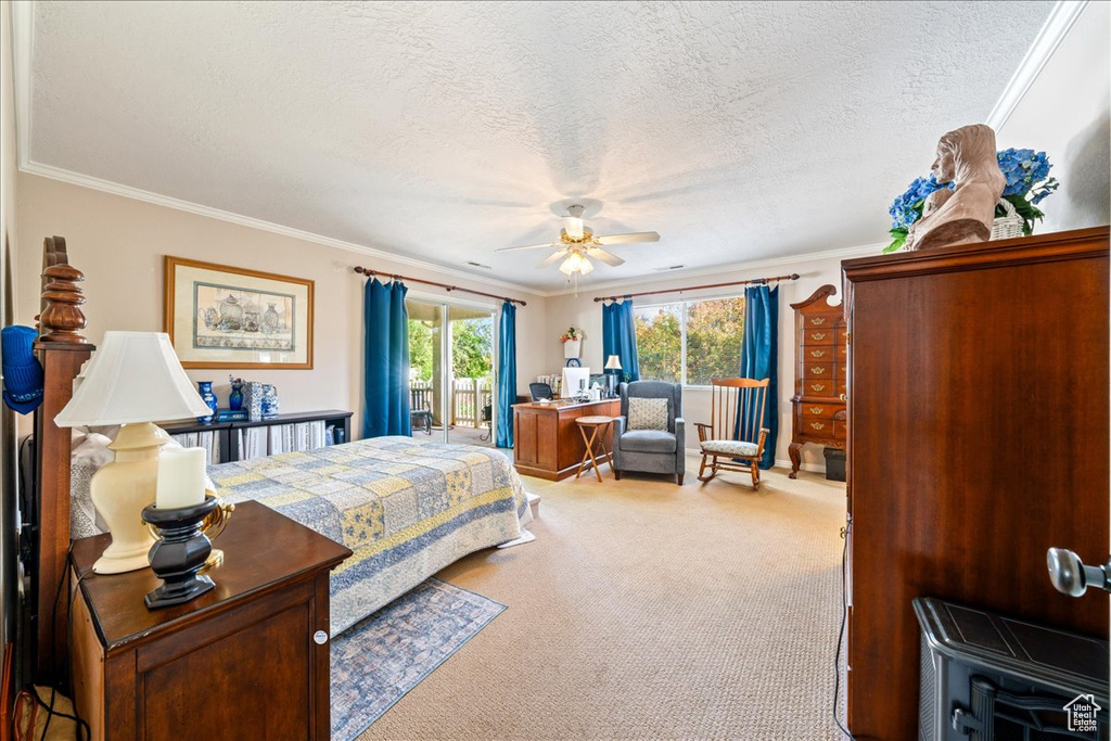 Carpeted bedroom featuring access to outside, a textured ceiling, ornamental molding, and a ceiling fan