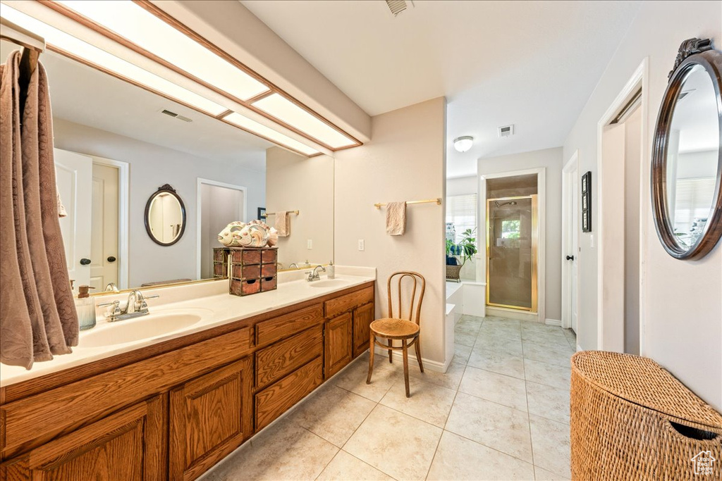 Bathroom featuring a sink, tile patterned flooring, a bath, and a stall shower