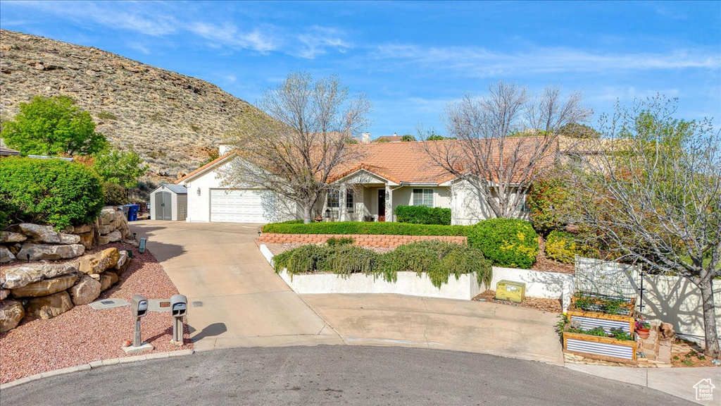 Single story home featuring an attached garage, a tiled roof, driveway, and fence