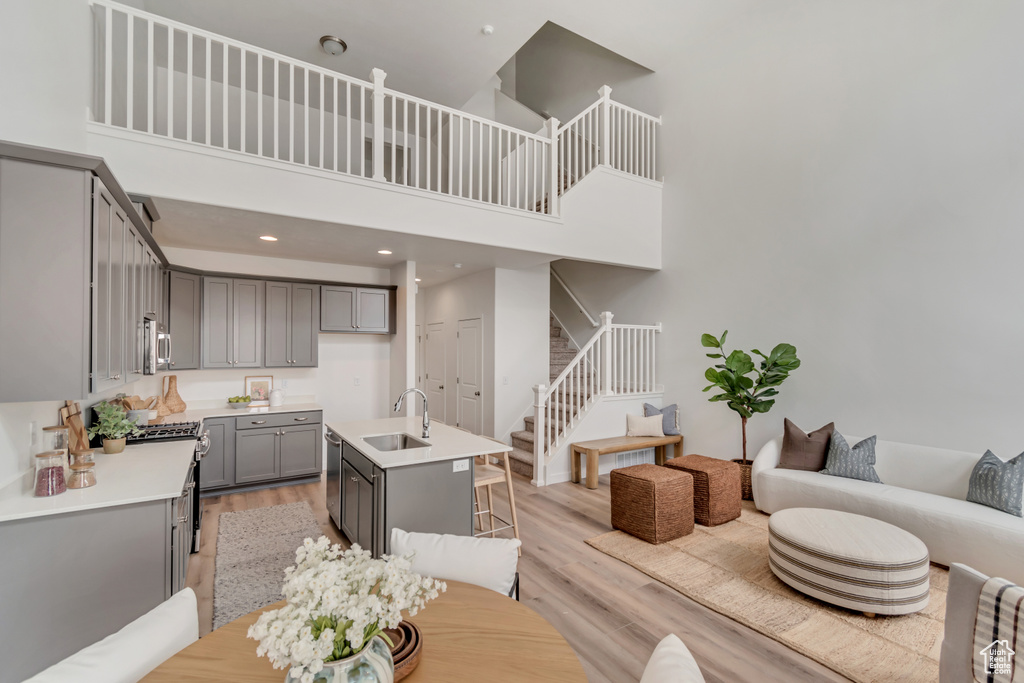 Interior space with a towering ceiling, stairs, and light wood-style floors