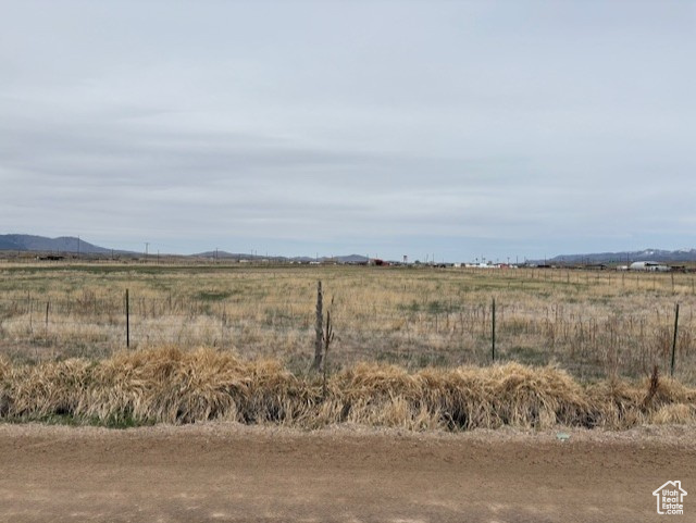 View of yard with a rural view and fence