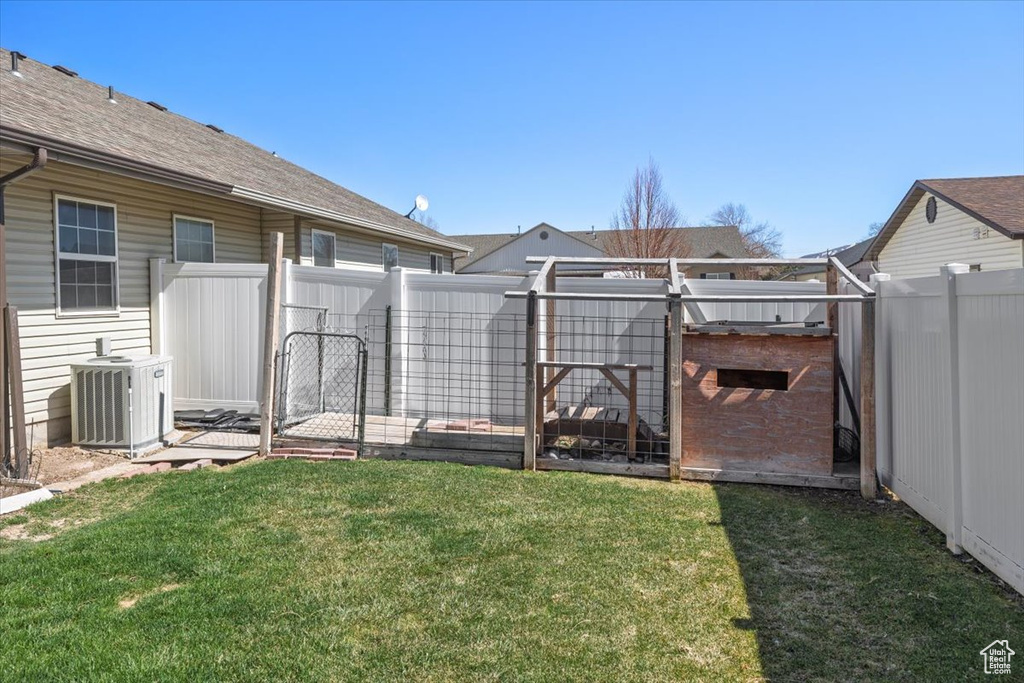 View of yard with central air condition unit and a fenced backyard