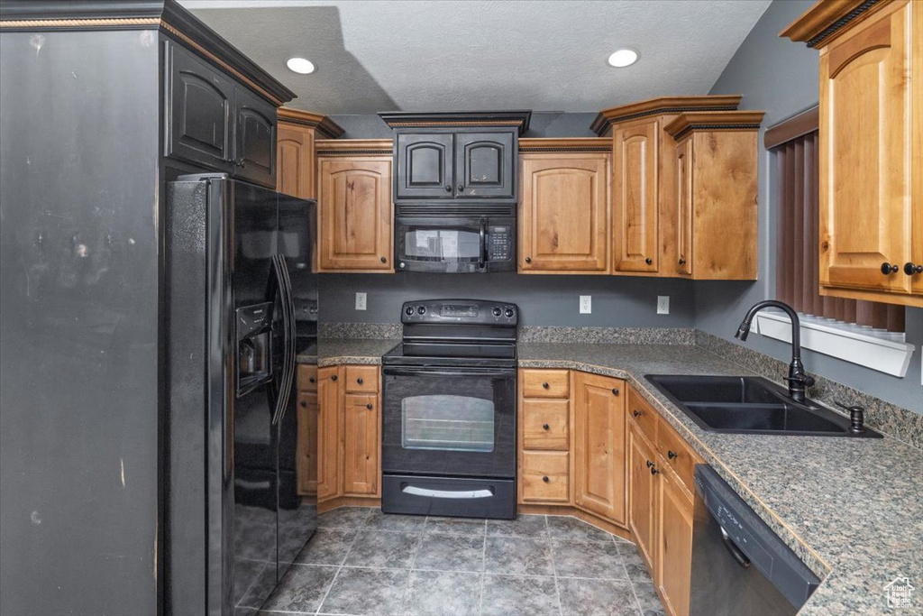 Kitchen with recessed lighting, a sink, black appliances, and a textured ceiling