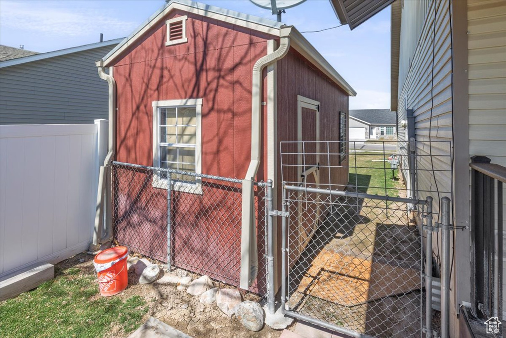 View of outdoor structure with an outbuilding and fence