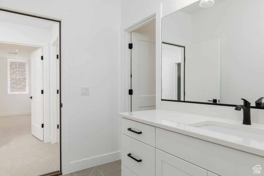 Bathroom with tile patterned flooring, baseboards, and vanity