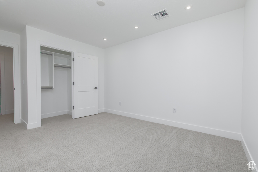 Unfurnished bedroom with visible vents, baseboards, recessed lighting, and light carpet