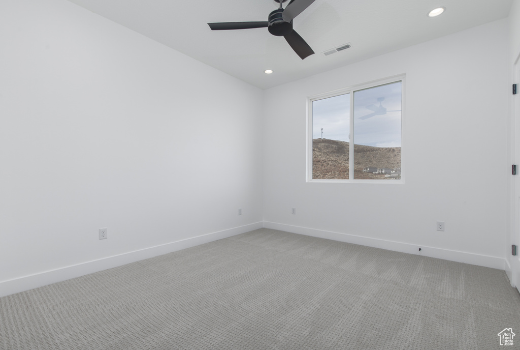 Empty room featuring light carpet, baseboards, visible vents, and recessed lighting