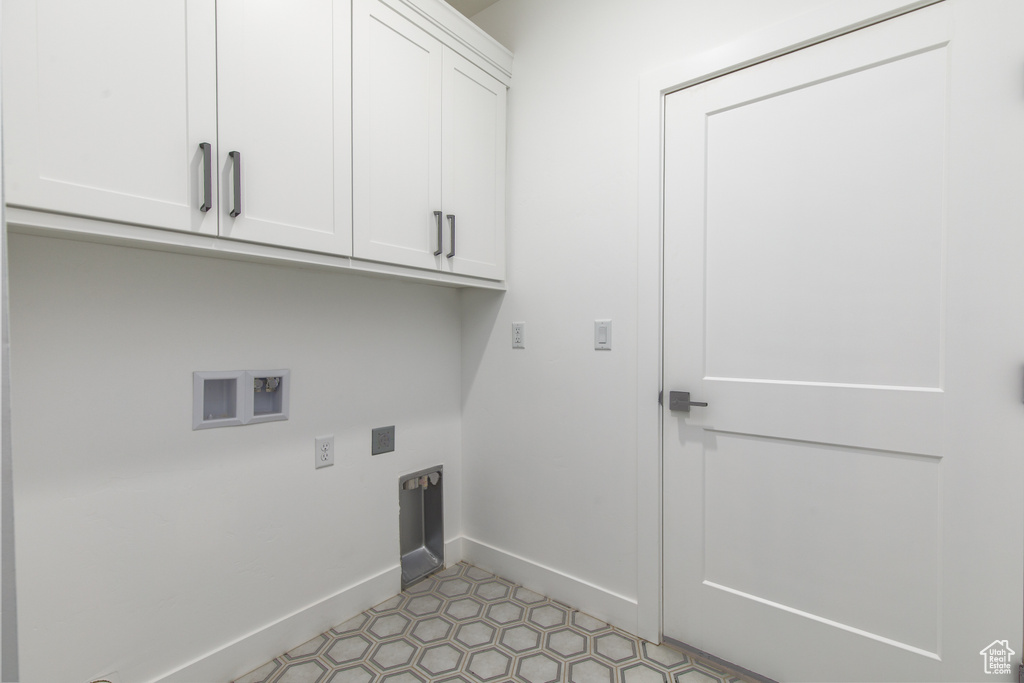 Washroom featuring cabinet space, baseboards, electric dryer hookup, and hookup for a washing machine