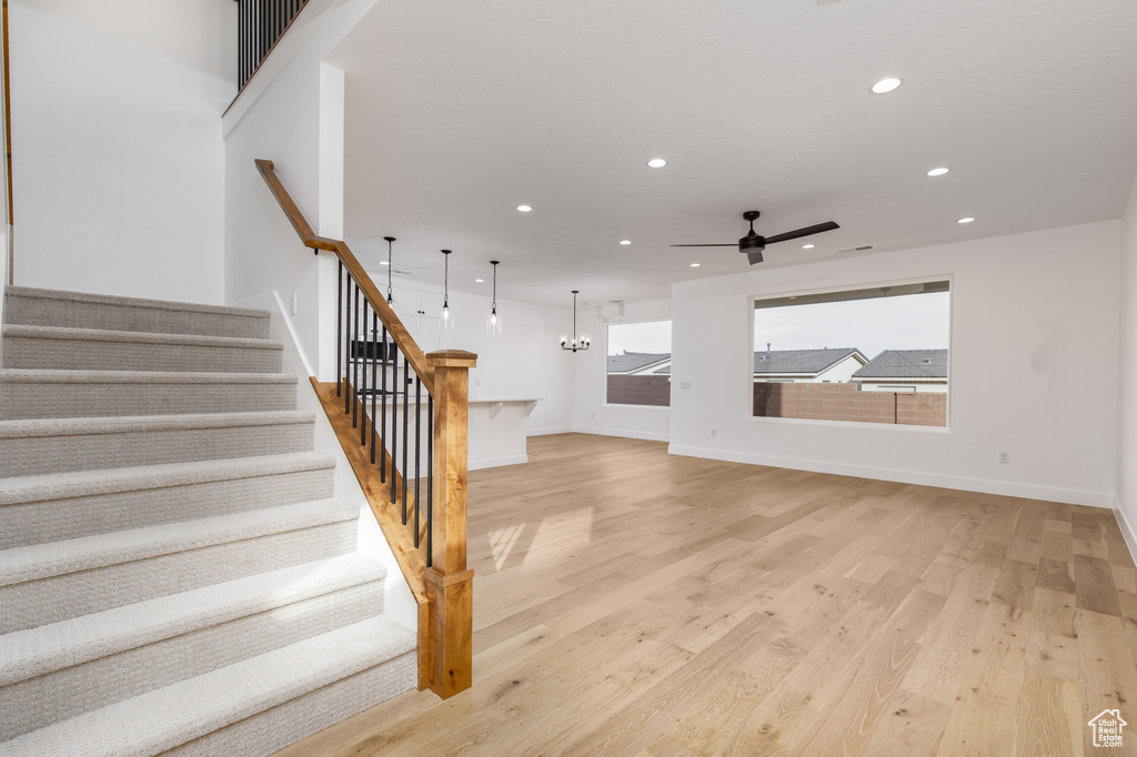 Stairway with recessed lighting, ceiling fan, baseboards, and wood finished floors