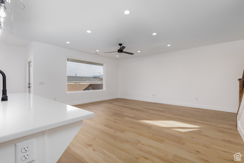 Unfurnished living room with recessed lighting, light wood-style flooring, baseboards, and ceiling fan