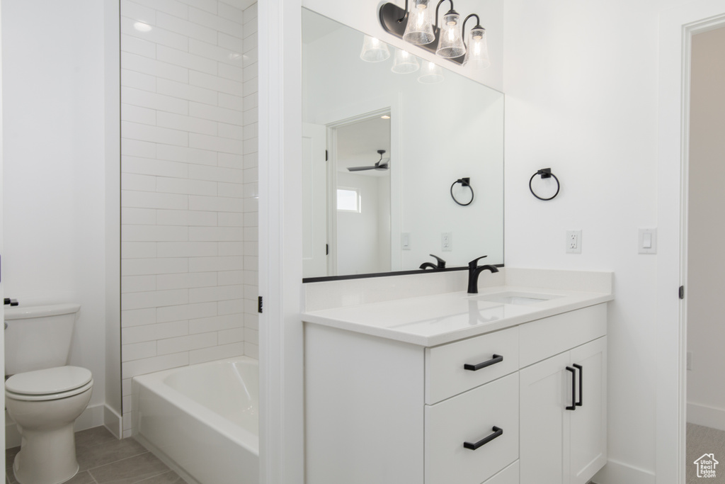 Bathroom featuring vanity, baseboards, toilet, and tub / shower combination