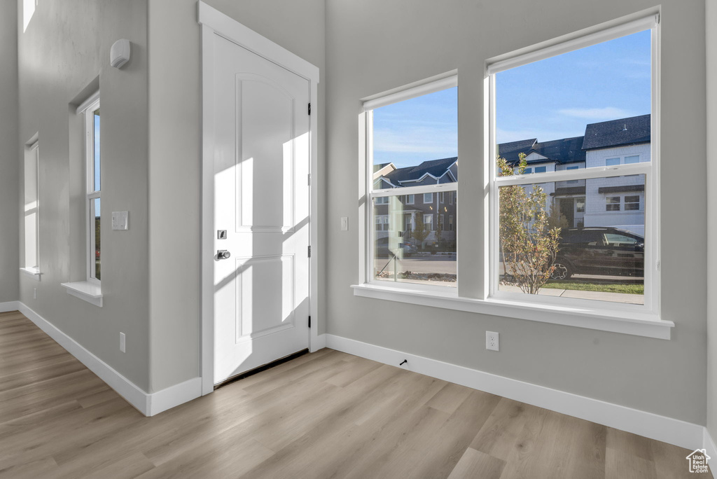 Entrance foyer with baseboards and wood finished floors