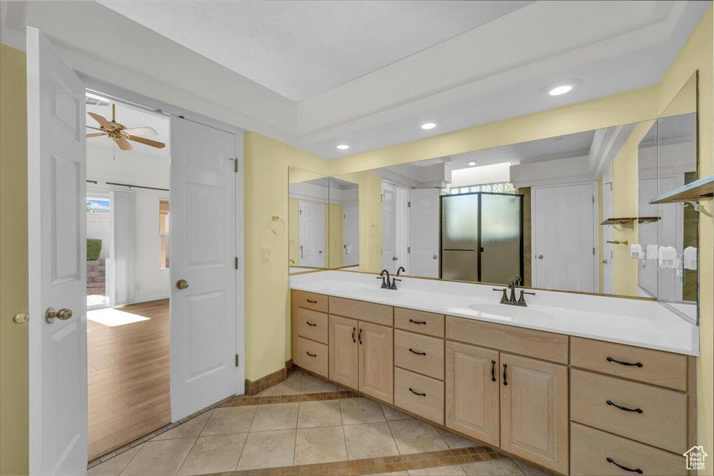 Full bathroom with tile patterned floors, double vanity, a sink, and baseboards