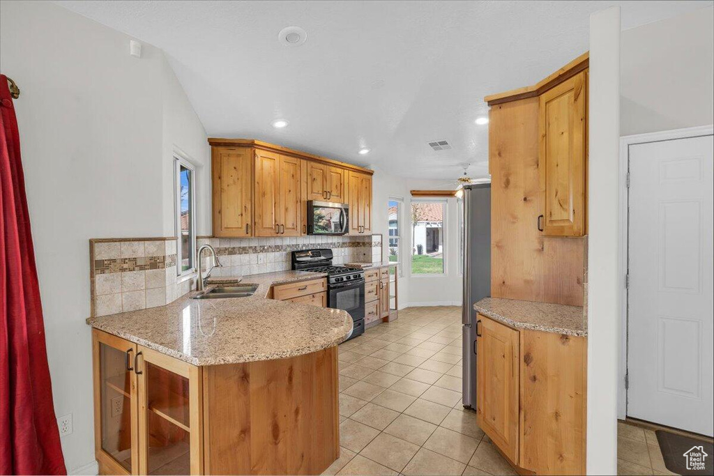 Kitchen with light tile patterned floors, tasteful backsplash, visible vents, a sink, and stainless steel appliances