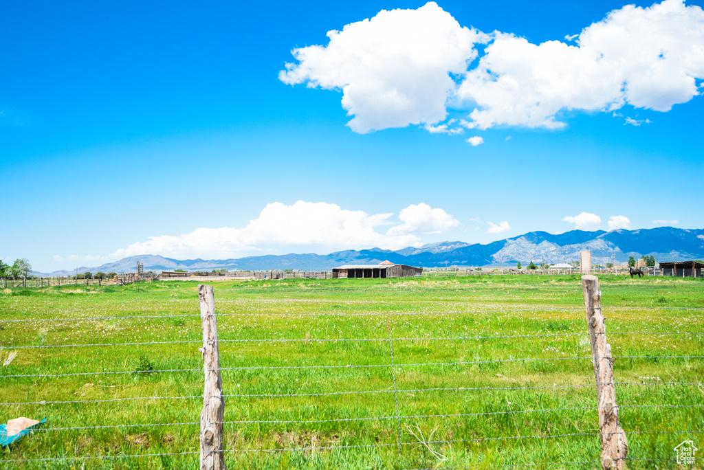 View of yard featuring a view of rural / pastoral area, a mountain view, an outdoor structure, and a pole building