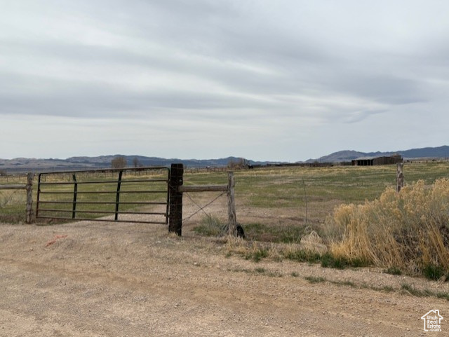 View of yard featuring a mountain view, fence, a gate, and a rural view