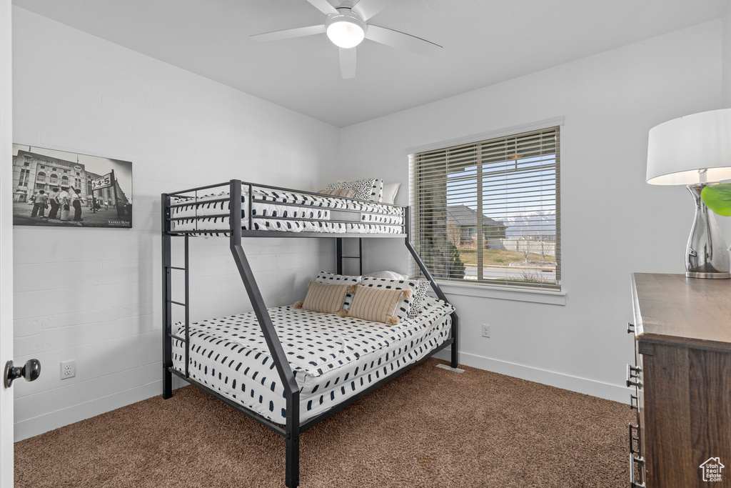 Carpeted bedroom with baseboards and a ceiling fan