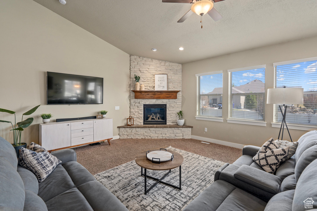 Living area featuring ceiling fan, carpet flooring, a wealth of natural light, and lofted ceiling