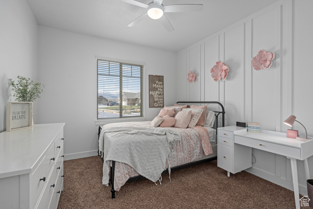 Bedroom featuring dark colored carpet, a ceiling fan, and baseboards