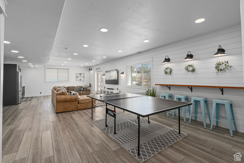 Recreation room featuring recessed lighting, a textured ceiling, and wood finished floors