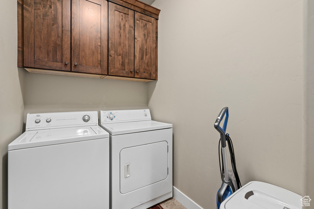 Laundry room featuring baseboards, washing machine and clothes dryer, and cabinet space