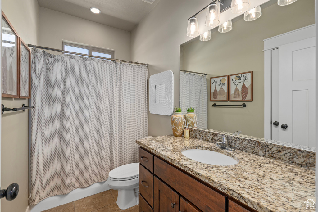 Full bathroom with shower / bath combination with curtain, toilet, tile patterned flooring, and vanity
