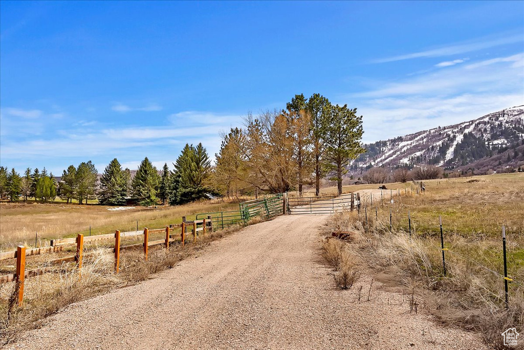 View of road with a rural view, a mountain view, and a gate