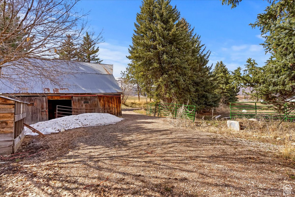 Exterior space featuring a barn, an outbuilding, and fence