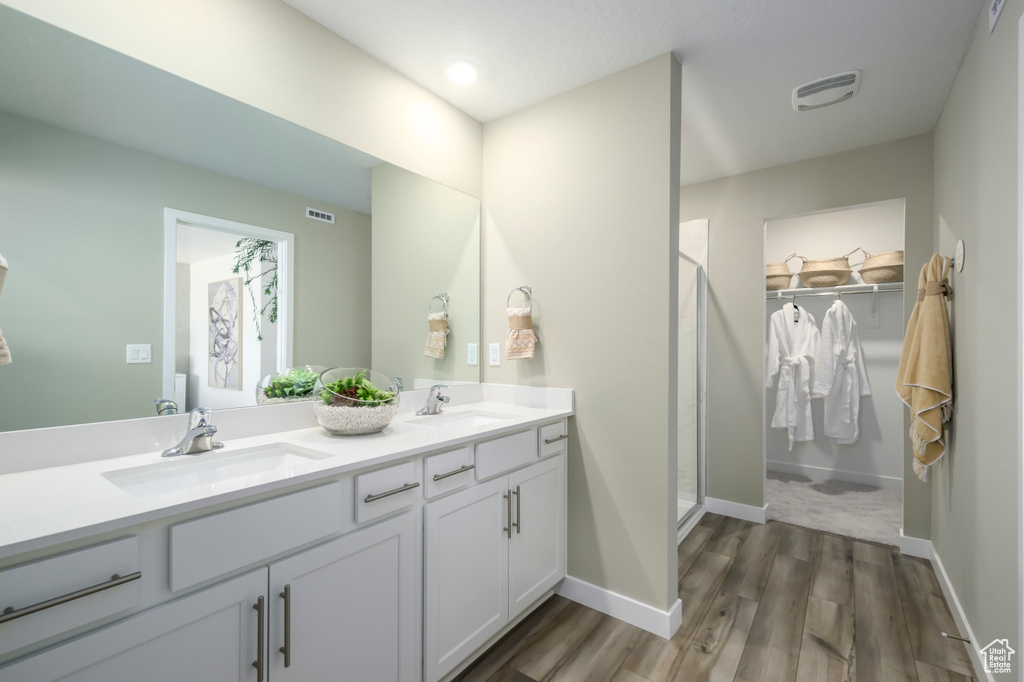 Bathroom with a sink, a stall shower, and wood finished floors
