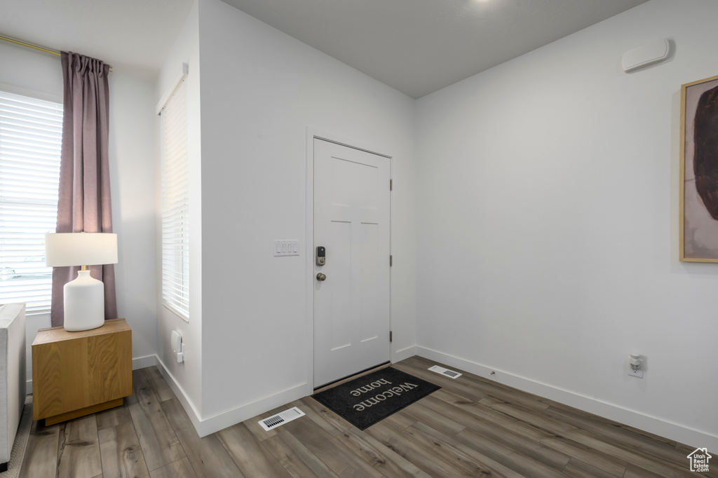 Foyer entrance featuring wood finished floors, baseboards, and visible vents