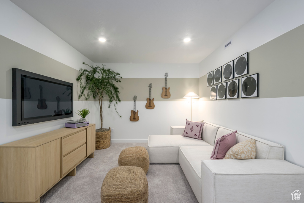 Living area with recessed lighting and light carpet