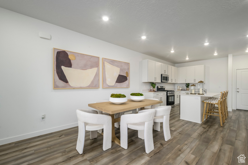 Dining area featuring recessed lighting, dark wood-style floors, baseboards, and a textured ceiling