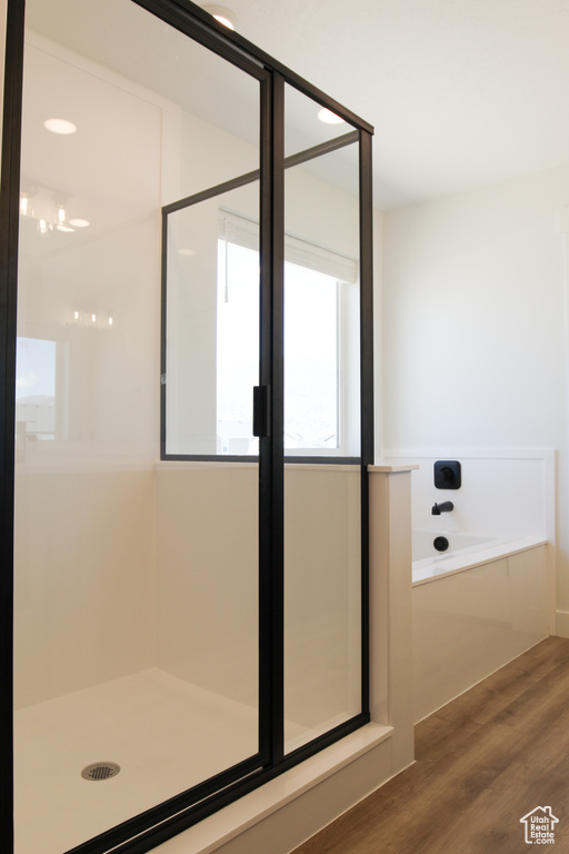 Full bathroom with a bath, a shower, and wood finished floors