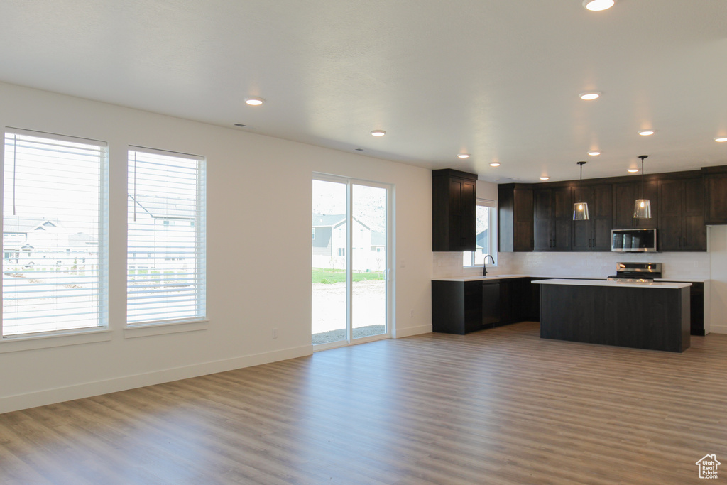 Kitchen featuring light wood-style flooring, recessed lighting, a center island, a sink, and stainless steel appliances