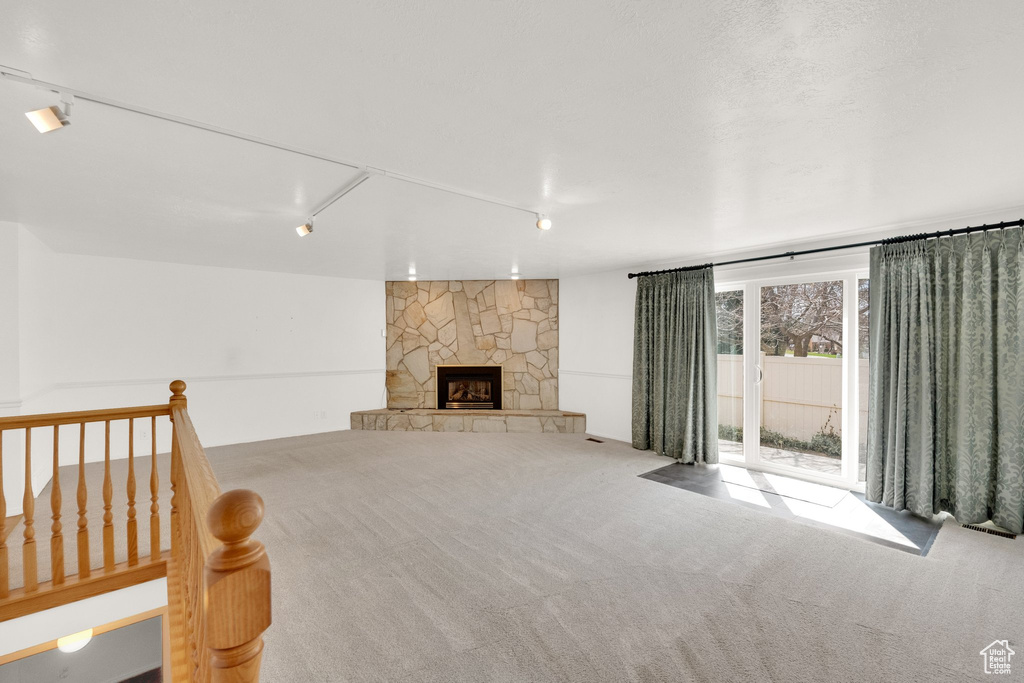 Interior space featuring carpet and a stone fireplace