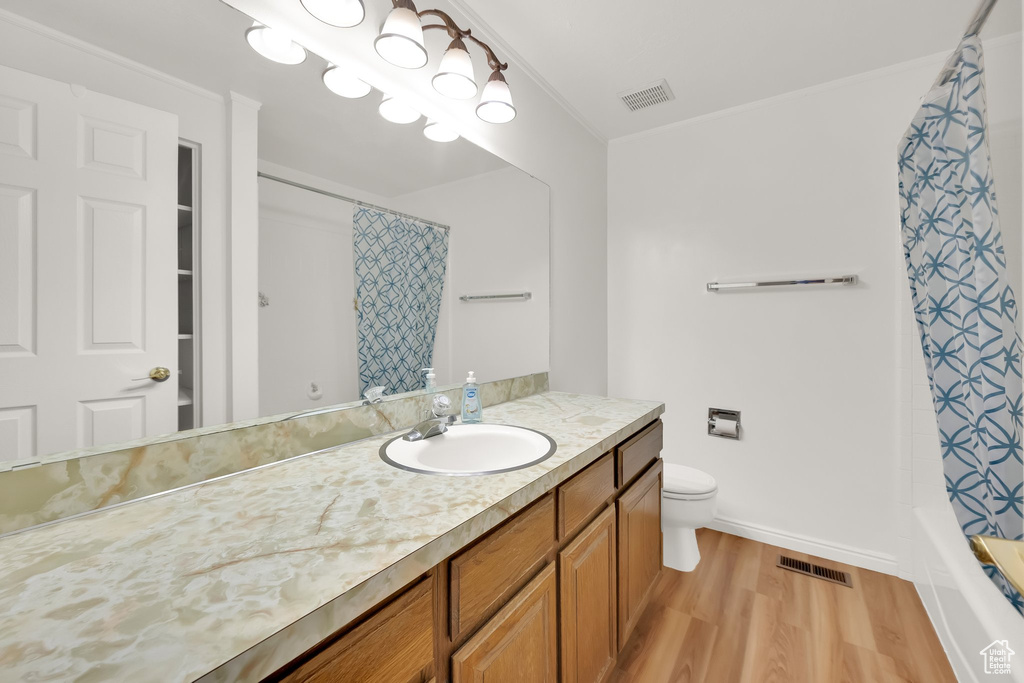 Bathroom featuring vanity, visible vents, toilet, and wood finished floors