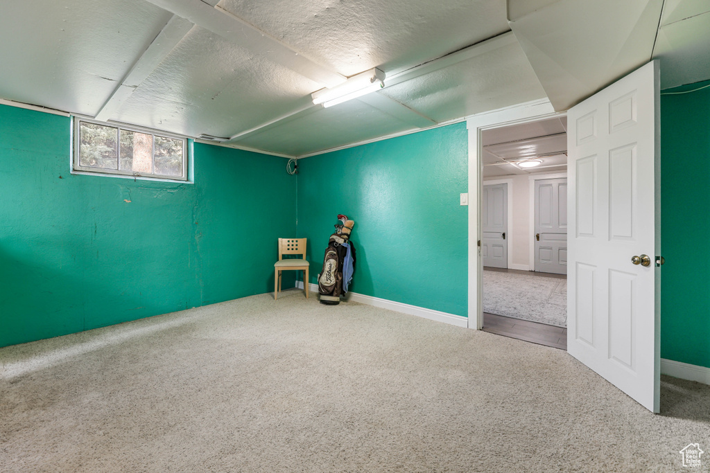 Interior space with carpet, a textured ceiling, and baseboards