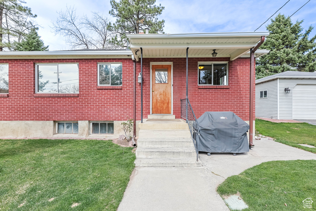 View of front facade with brick siding and a front lawn