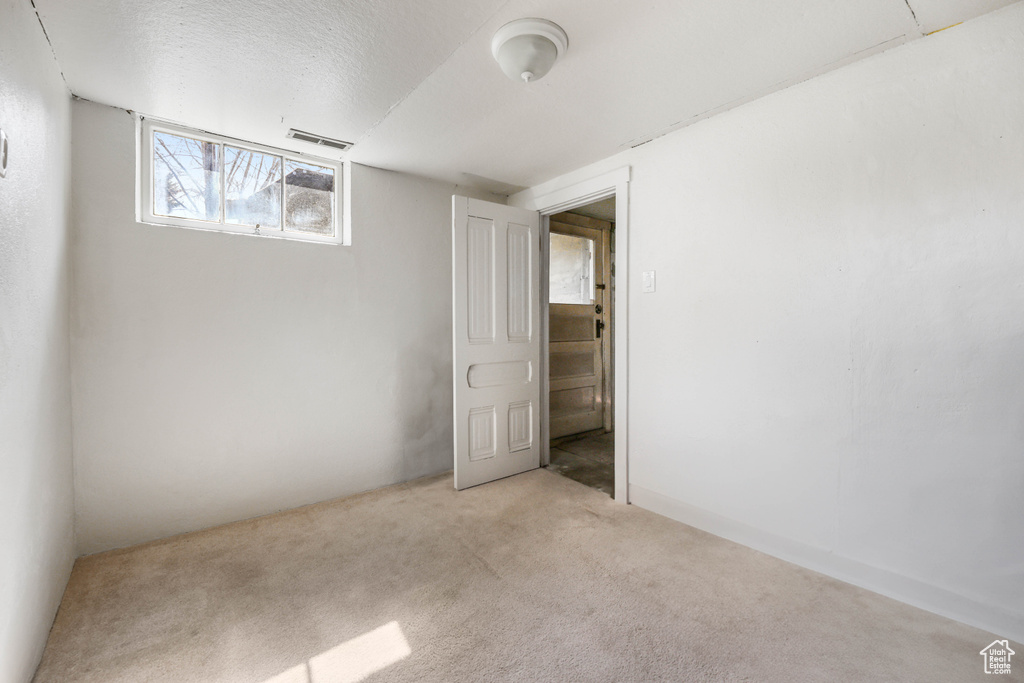 Interior space featuring visible vents, carpet flooring, and a textured ceiling