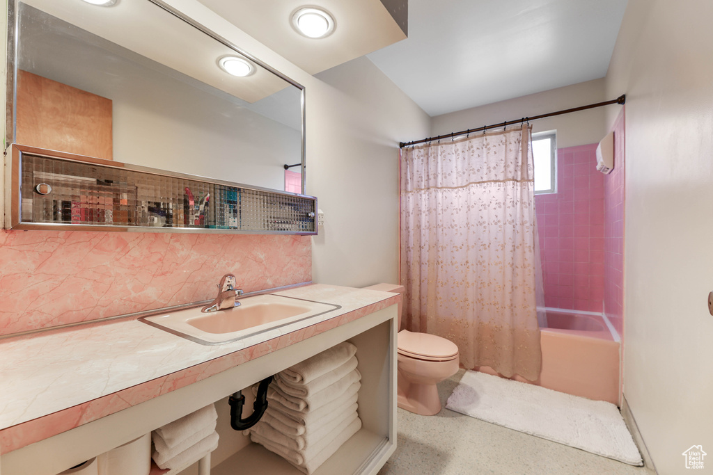 Full bath with toilet, tasteful backsplash, vanity, and shower / tub combo with curtain