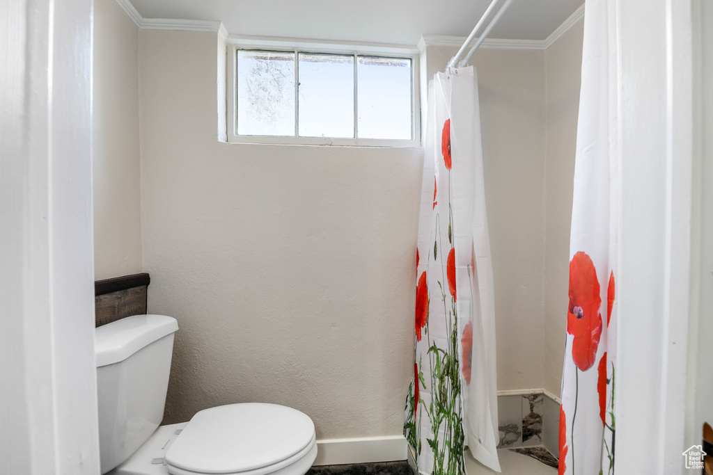 Full bath with a shower with shower curtain, ornamental molding, and toilet