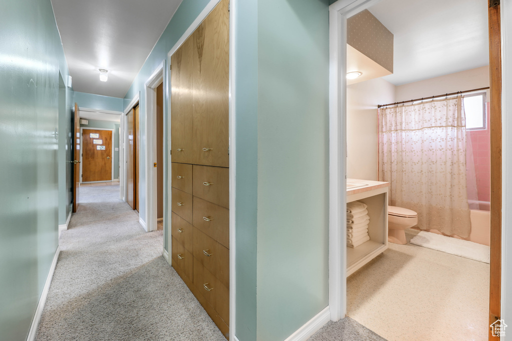 Hallway featuring baseboards and carpet flooring