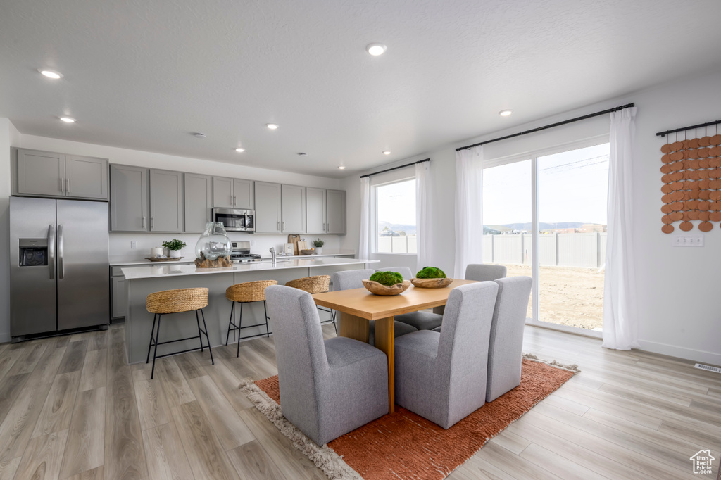 Dining area featuring baseboards, light wood-type flooring, and recessed lighting