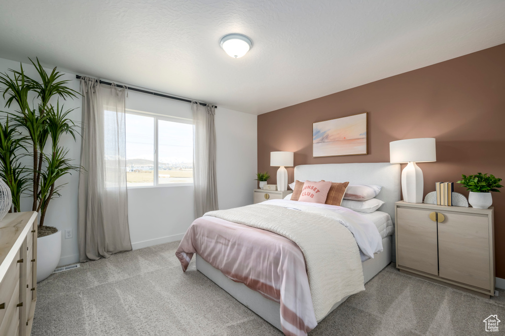 Bedroom featuring light carpet