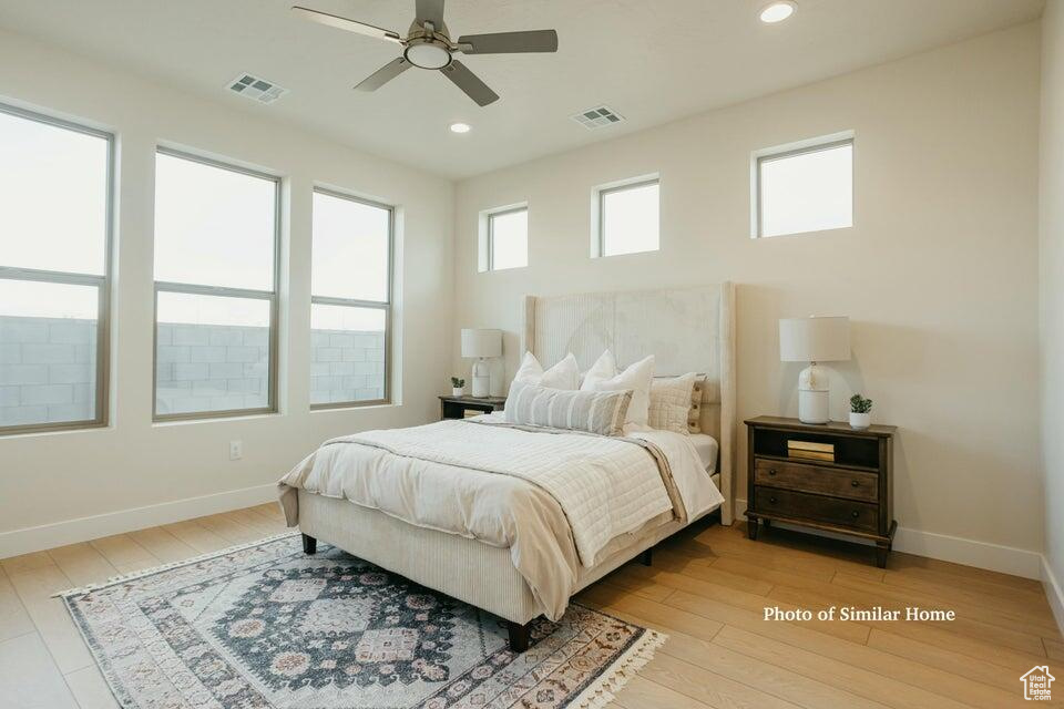 Bedroom with light wood-style flooring, baseboards, visible vents, and recessed lighting
