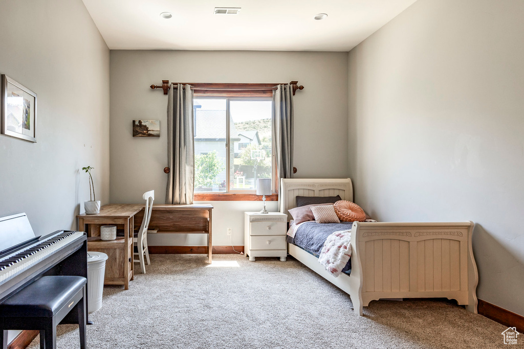 Carpeted bedroom featuring visible vents and baseboards