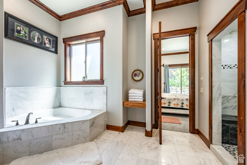 Full bath with walk in shower, baseboards, crown molding, connected bathroom, and a garden tub